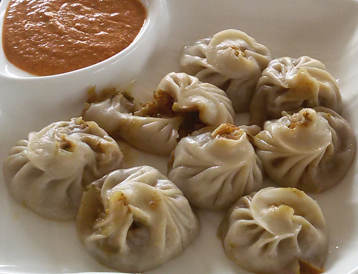 Authentic Nepali momos, steamed dumplings enjoyed on a trekking adventure in the Annapurna Region.