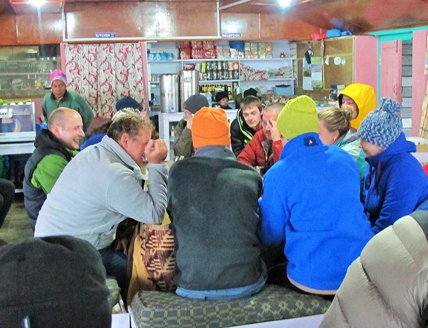 Trekkers unwinding in a cozy common room, sharing stories from the Annapurna Trek in Nepal.