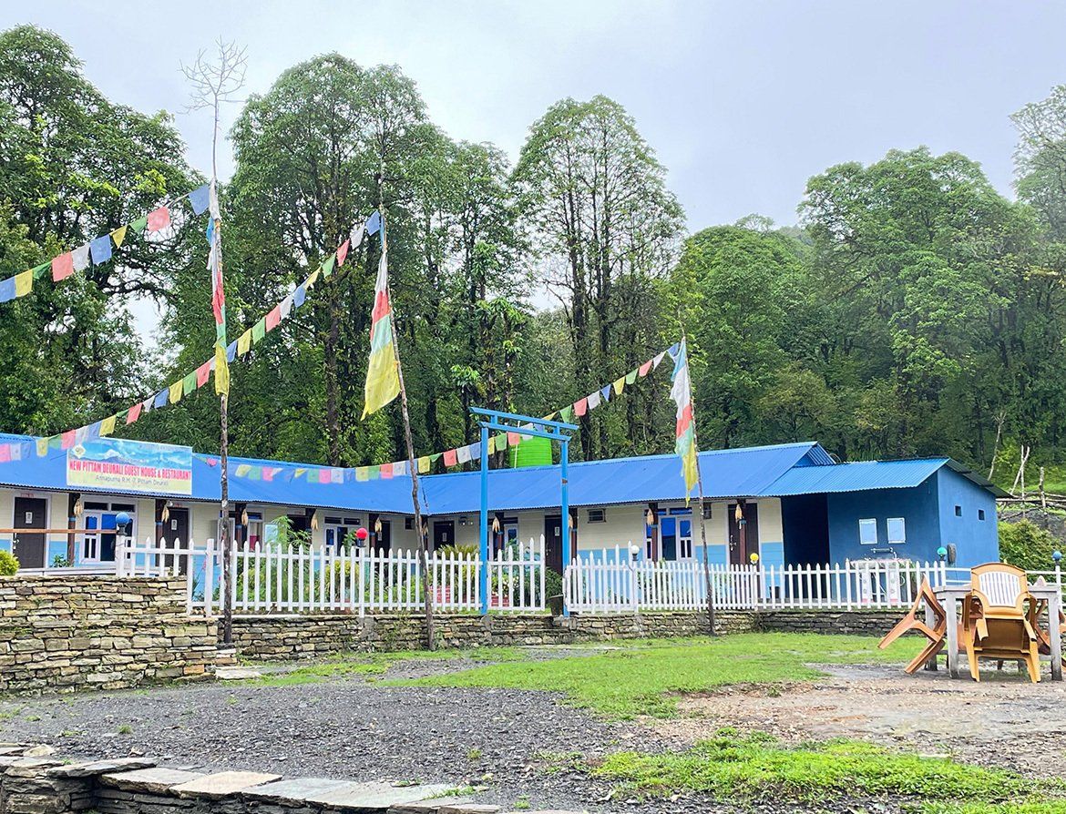 Colorful lodge adorned with prayer flags, offering comfortable accommodations on the Annapurna Trek in Nepal.