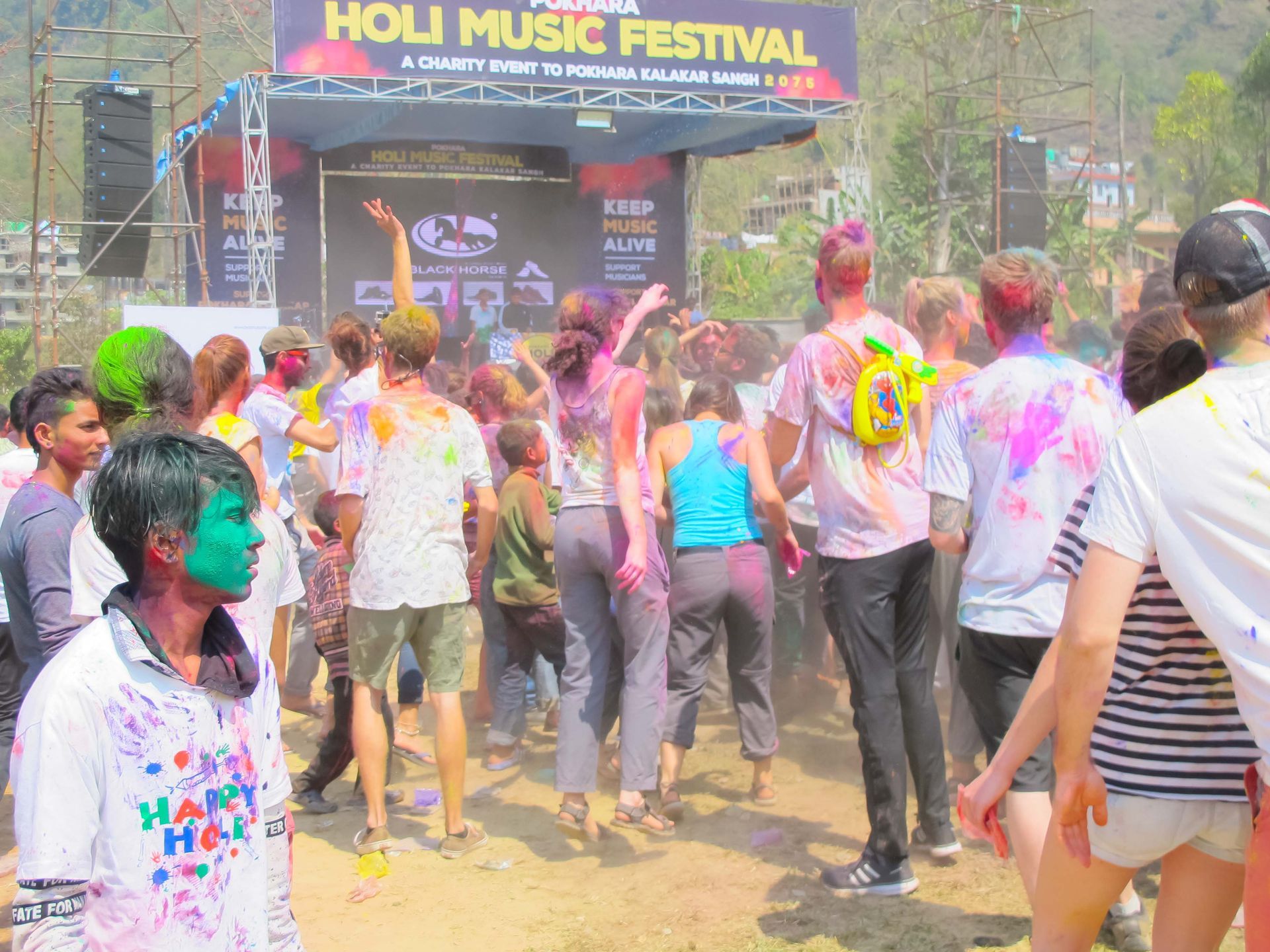 Crowd participating in the Holi Music Festival in Pokhara, with colorful powders filling the air during the celebration.