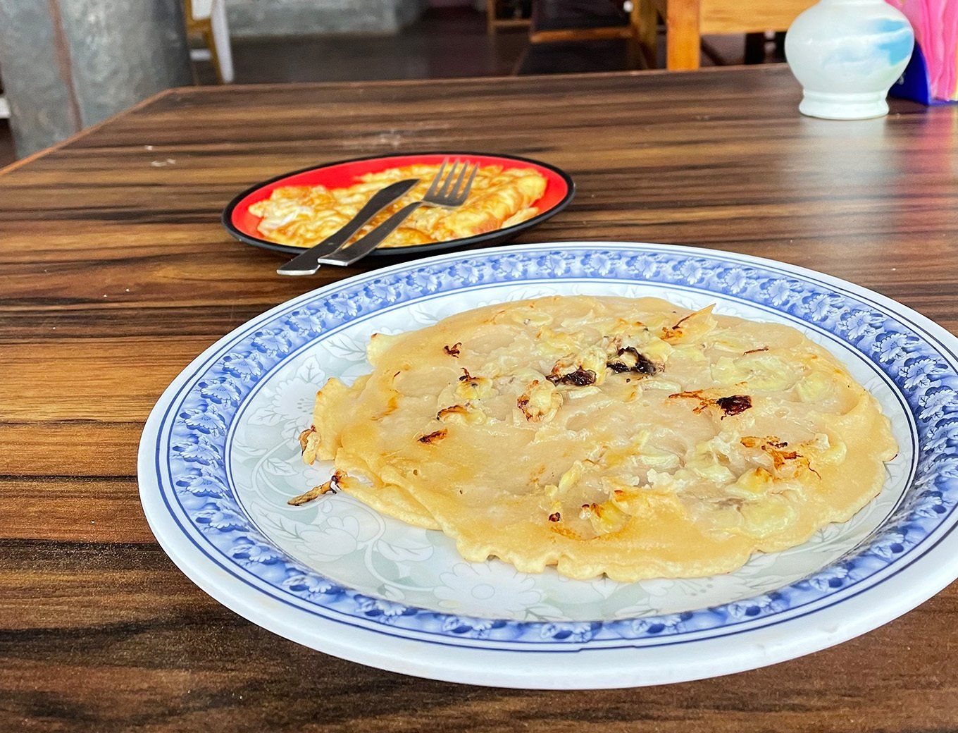 Nutritious breakfast on a trek in Nepal, including pancakes, fruits, and breathtaking mountain views.