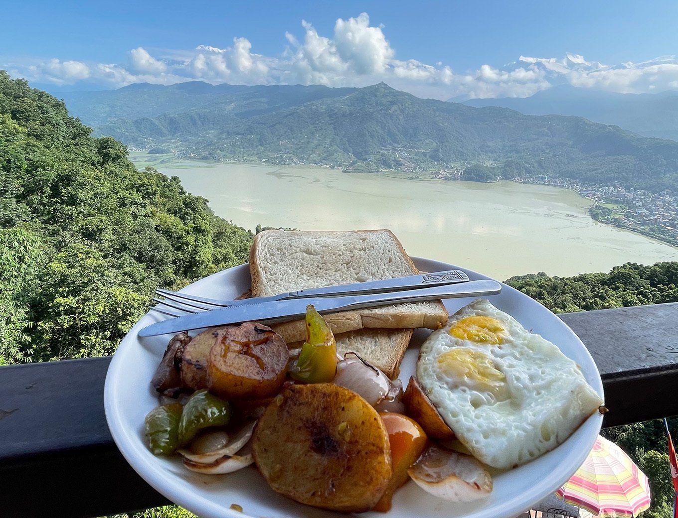 Scenic breakfast spread near World Peace Pagoda in Pokhara in Nepal, featuring local dishes with stunning views.
