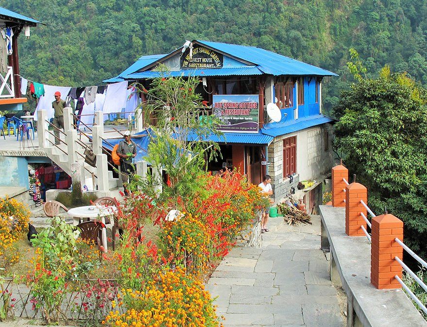 Charming cottage nestled in the lush greenery on the Annapurna Base Camp Trek in Nepal, a perfect resting spot for trekkers.