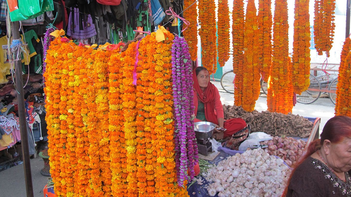 A bustling local market in Nepal, with vendors displaying fresh flowers.