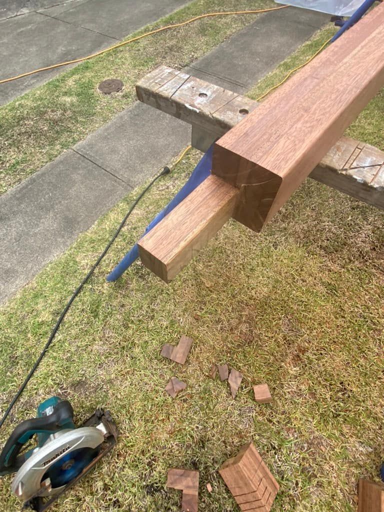 Wooden Beams Being Cut Outdoors With a Circular Saw — Kalora Carpentry & Restorations in Charlestown, NSW