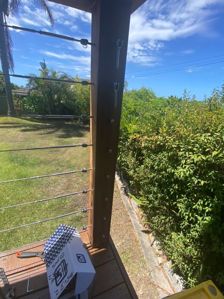 Wooden Deck With Cable Railing, Green Bushes, Blue Sky — Kalora Carpentry & Restorations in Merewether, NSW