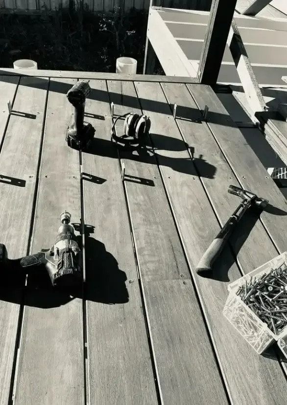 Tools on a Wooden Deck: Drills, Hammer, Screws, and Fasteners — Kalora Carpentry & Restorations in Charlestown, NSW