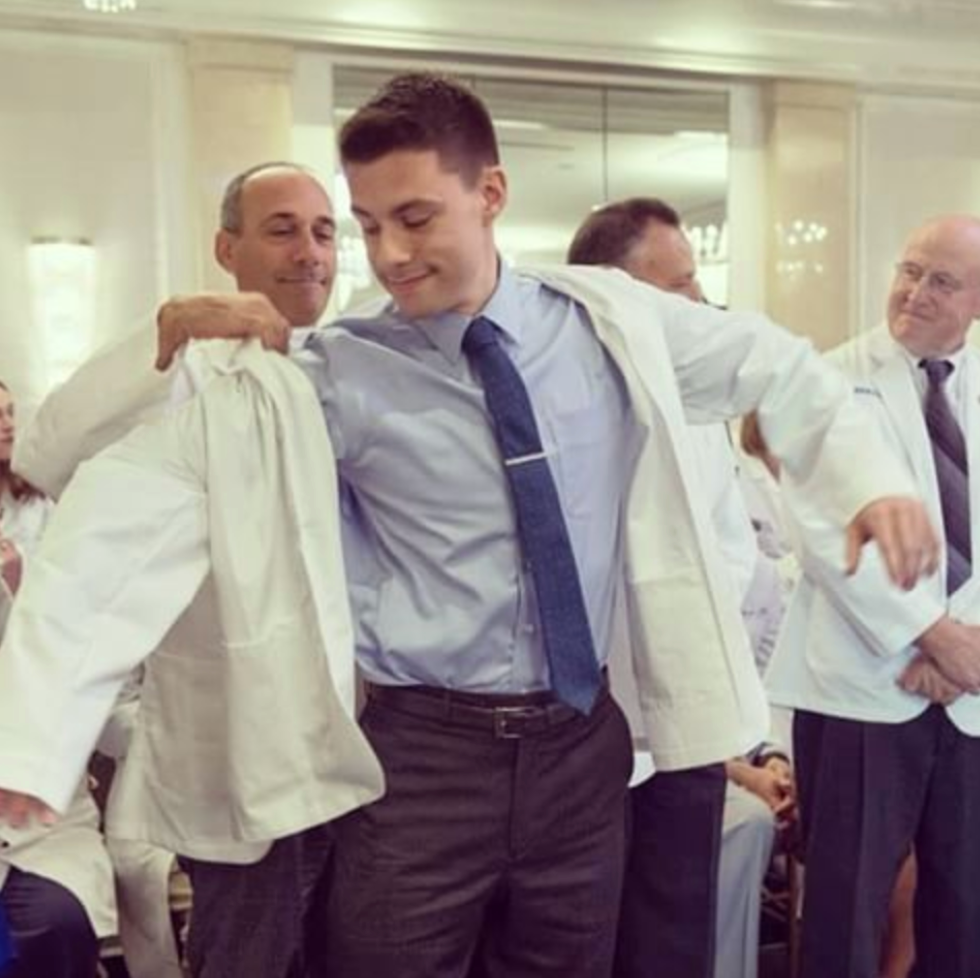 A group of men in white coats and ties are posing for a picture