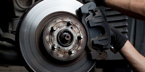 Brakes — Man Repairing Car Brake in Stoughton, WI