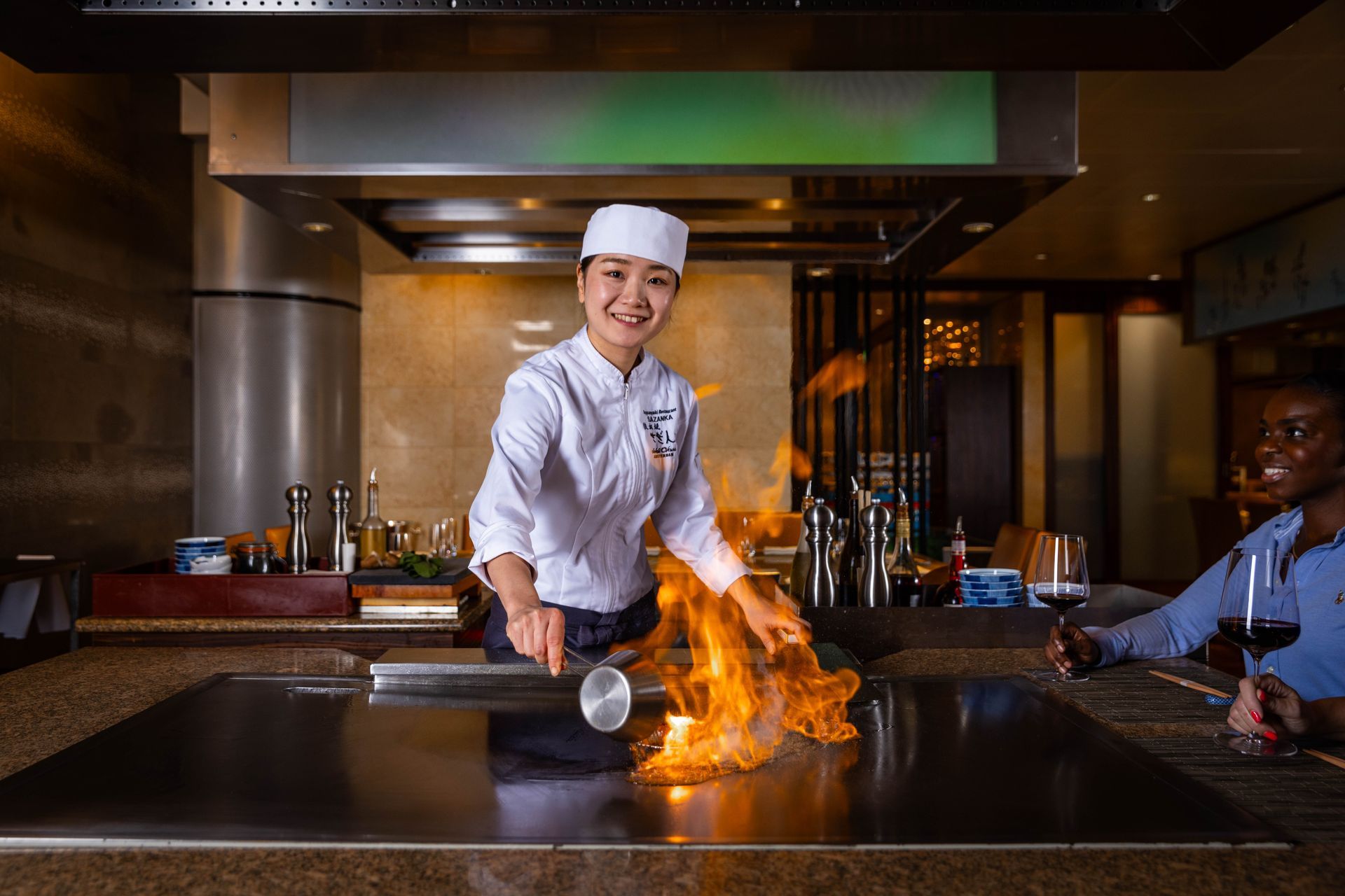 A woman is cooking food on a grill in a restaurant.