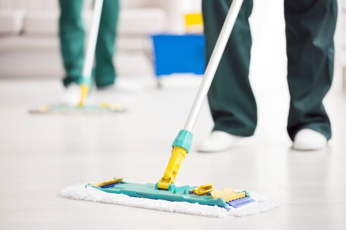 addetto alle pulizie passa una scopa mop sul pavimento
