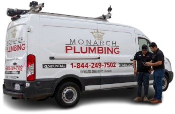 Two technicians stand beside a white Monarch Plumbing work van.
