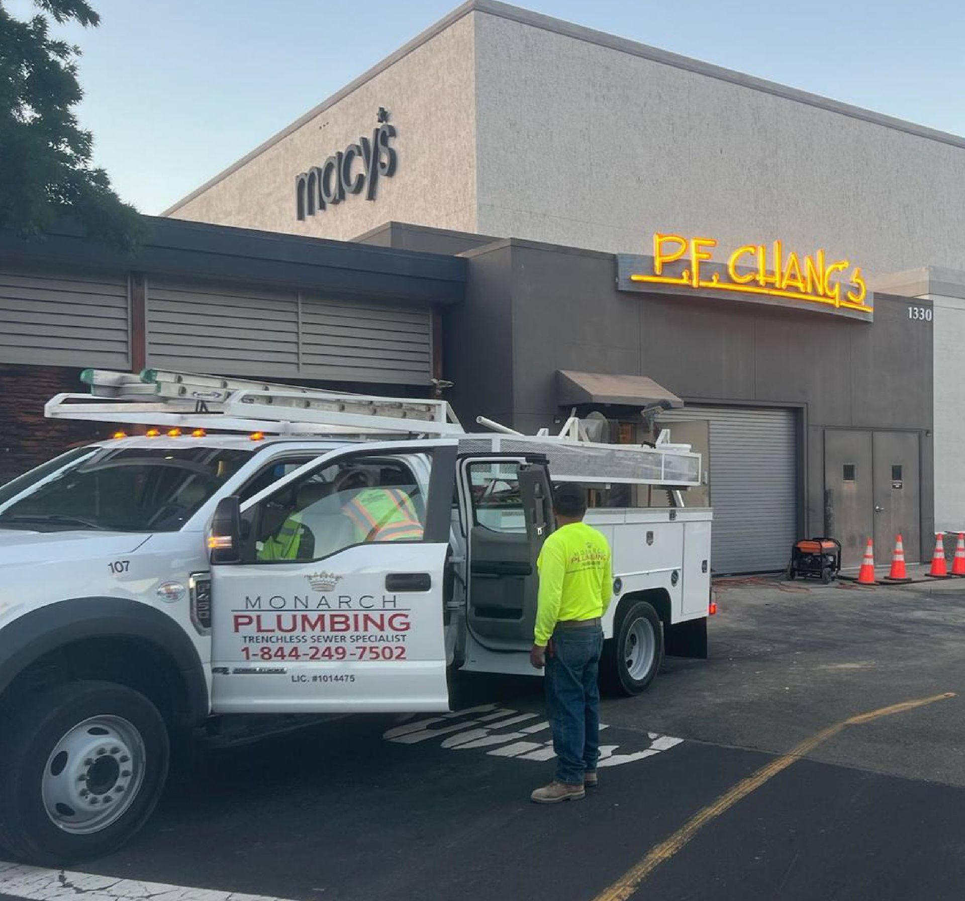Monarch Plumbing service truck and worker outside a Macy’s store at a mall parking lot