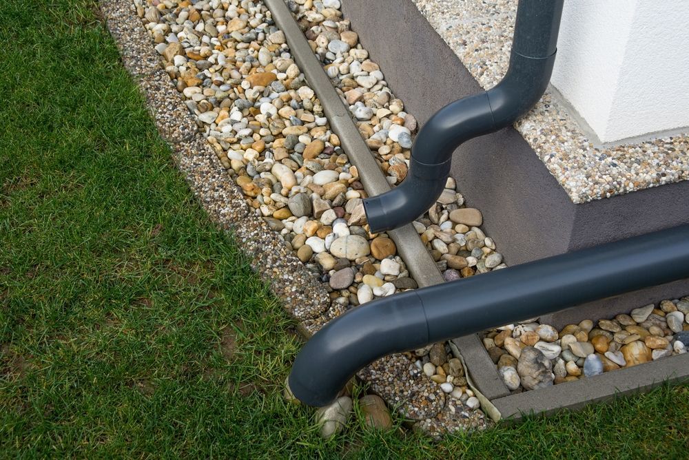 A black gutter is sitting on the side of a house.