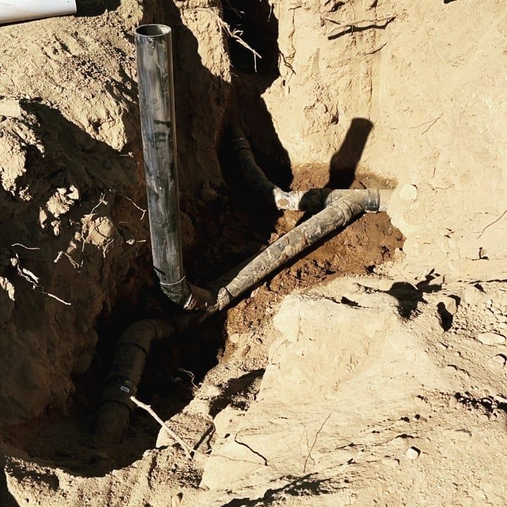 A hole in the ground with a pipe in it