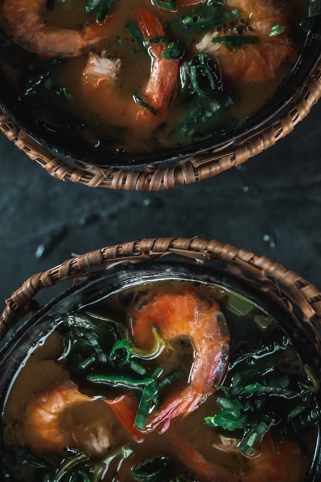 Fried savory snacks with dipping sauces on a decorated tray, with a drink on a wooden table.