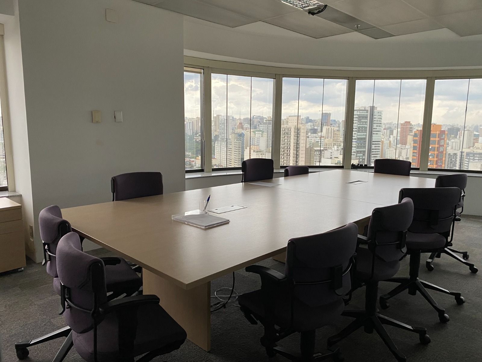 Uma sala de conferências com uma mesa longa e cadeiras