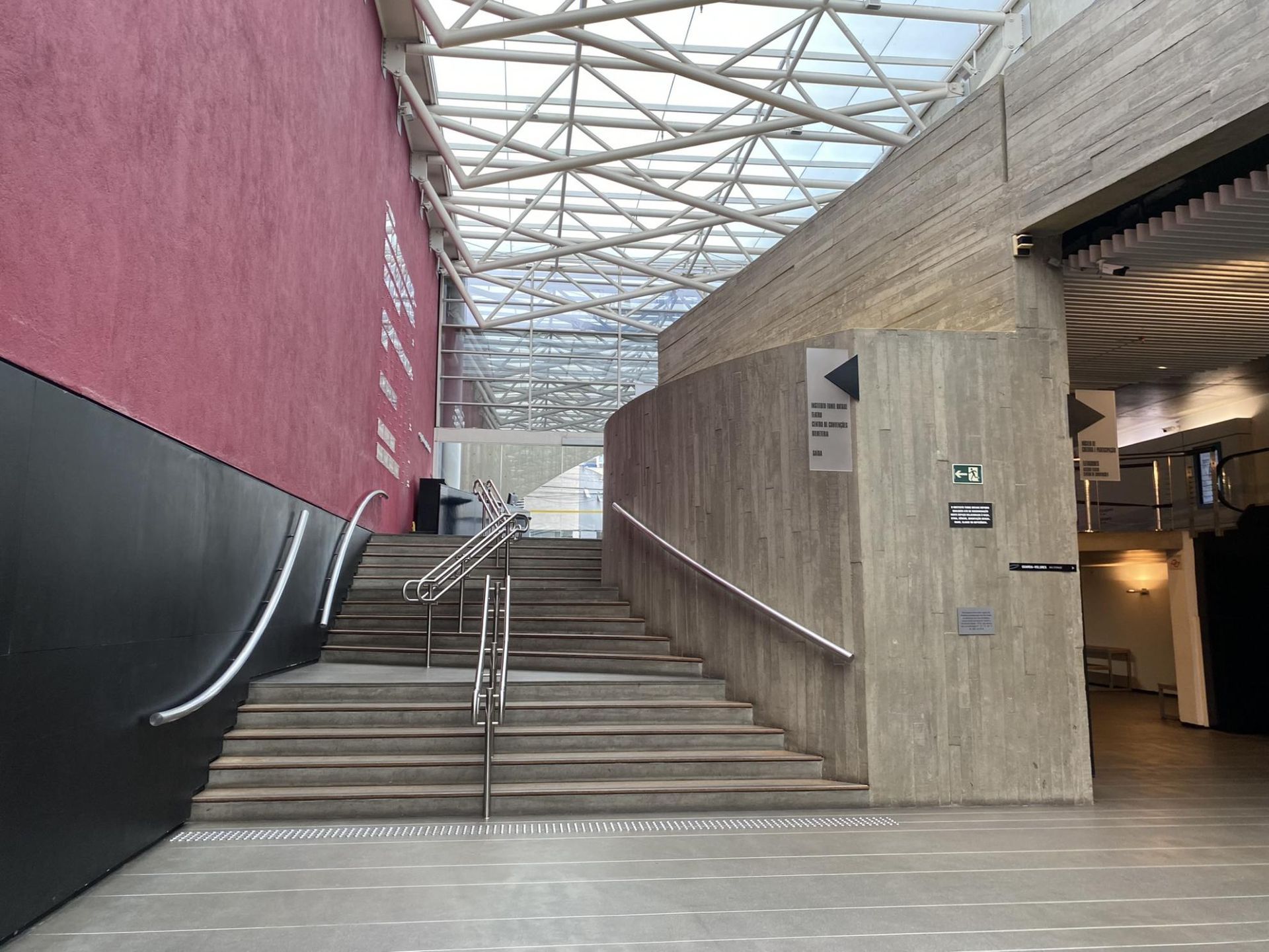 Uma escada que leva a um edifício com telhado de vidro.