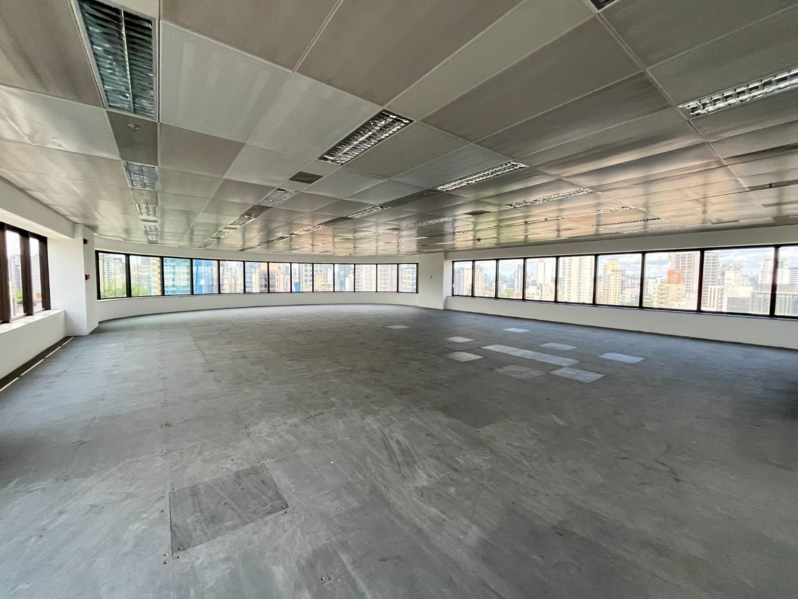 Uma grande sala vazia com muitas janelas e um teto.