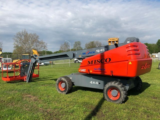 A misco lift is parked in a grassy field