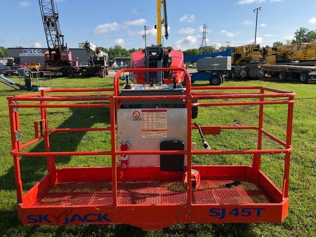 A skyjack sj 45t is parked in a grassy field.