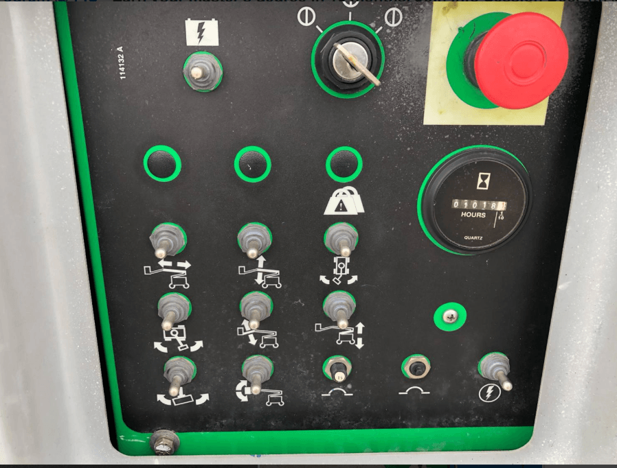A green and black control panel with buttons and a red button