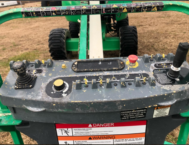 A green tractor with a warning label on it