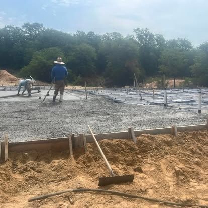 A group of construction workers are working on a concrete foundation.