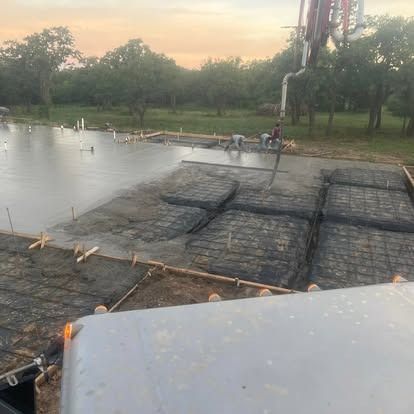 A concrete floor is being poured on a construction site.