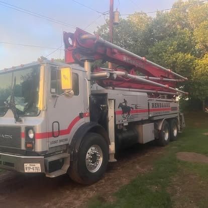 A concrete pump truck is parked on the side of the road.