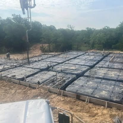 A large concrete slab is being poured on a construction site.
