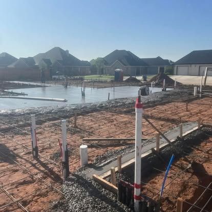 A construction site with a lot of pipes in the dirt.
