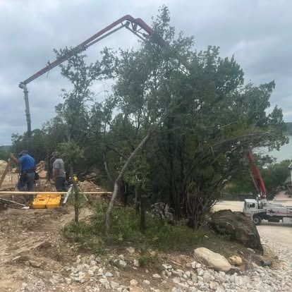 A concrete pump is being used to pour concrete into a hole in the ground.