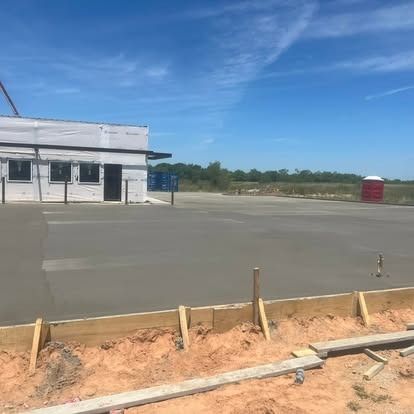 A building is being built next to a concrete driveway.