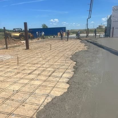 A group of construction workers are working on a concrete driveway.