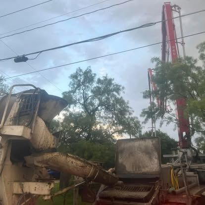 A concrete pump is pouring concrete into a truck.
