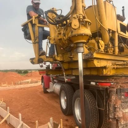 A man is sitting on the back of a yellow truck.