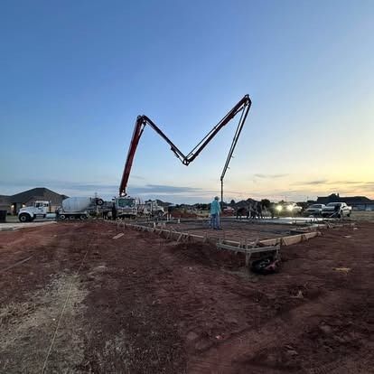 A concrete pump is being used to pour concrete on a construction site.