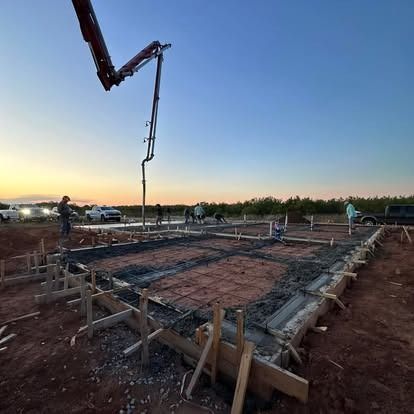 A concrete pump is being used to pour concrete on a construction site.