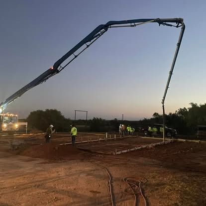 A concrete pump is being used to pour concrete on a construction site.