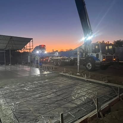 A concrete pump truck is pumping concrete into a concrete slab.
