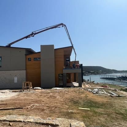 A large house is being built next to a body of water.