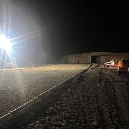 A construction site at night with a lot of lights on.