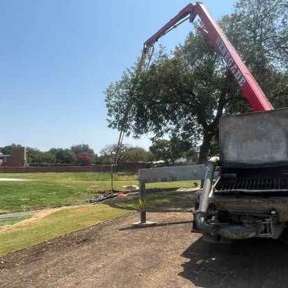 A red crane is attached to the back of a truck.