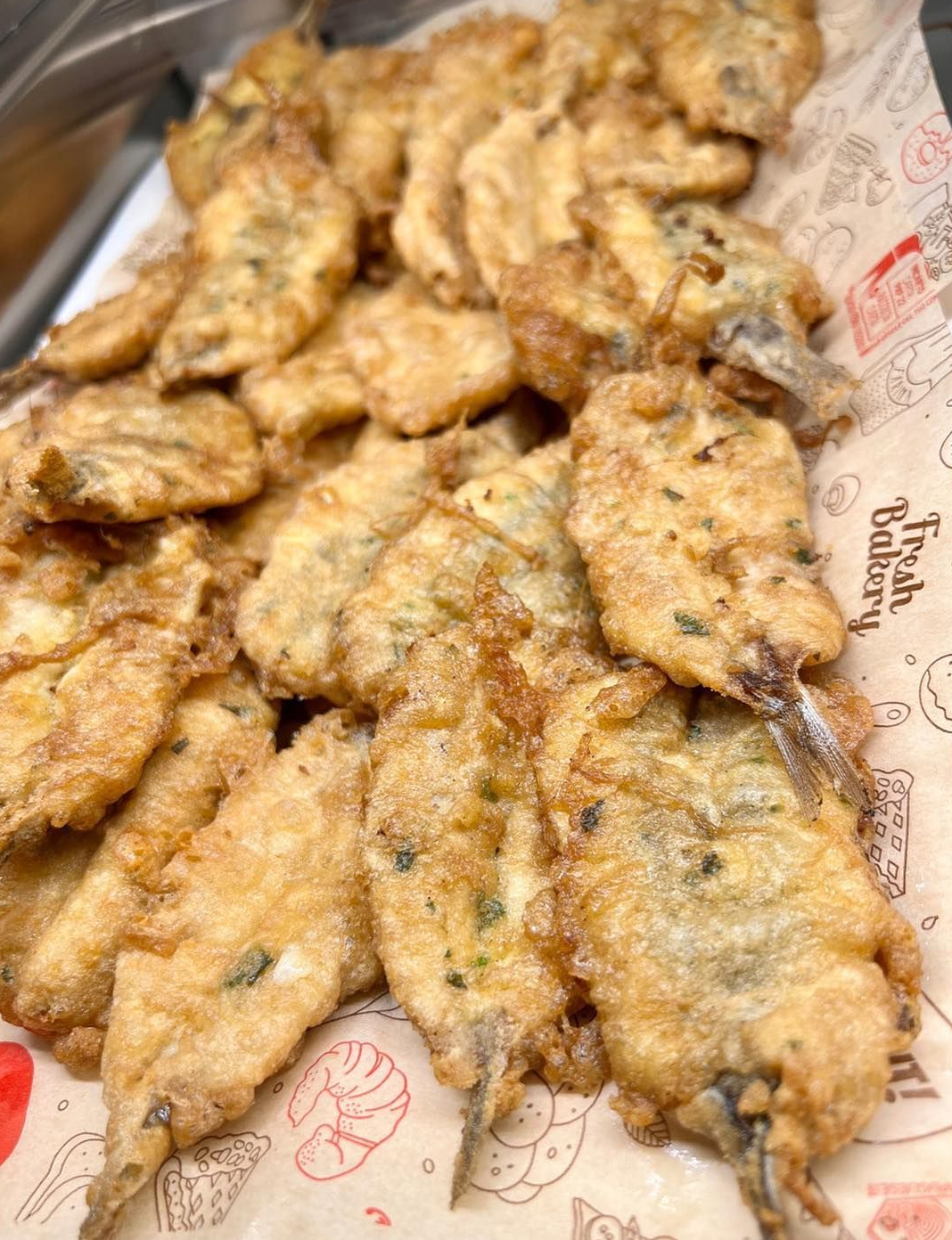Polpette di pesce fritte su carta fantasia.