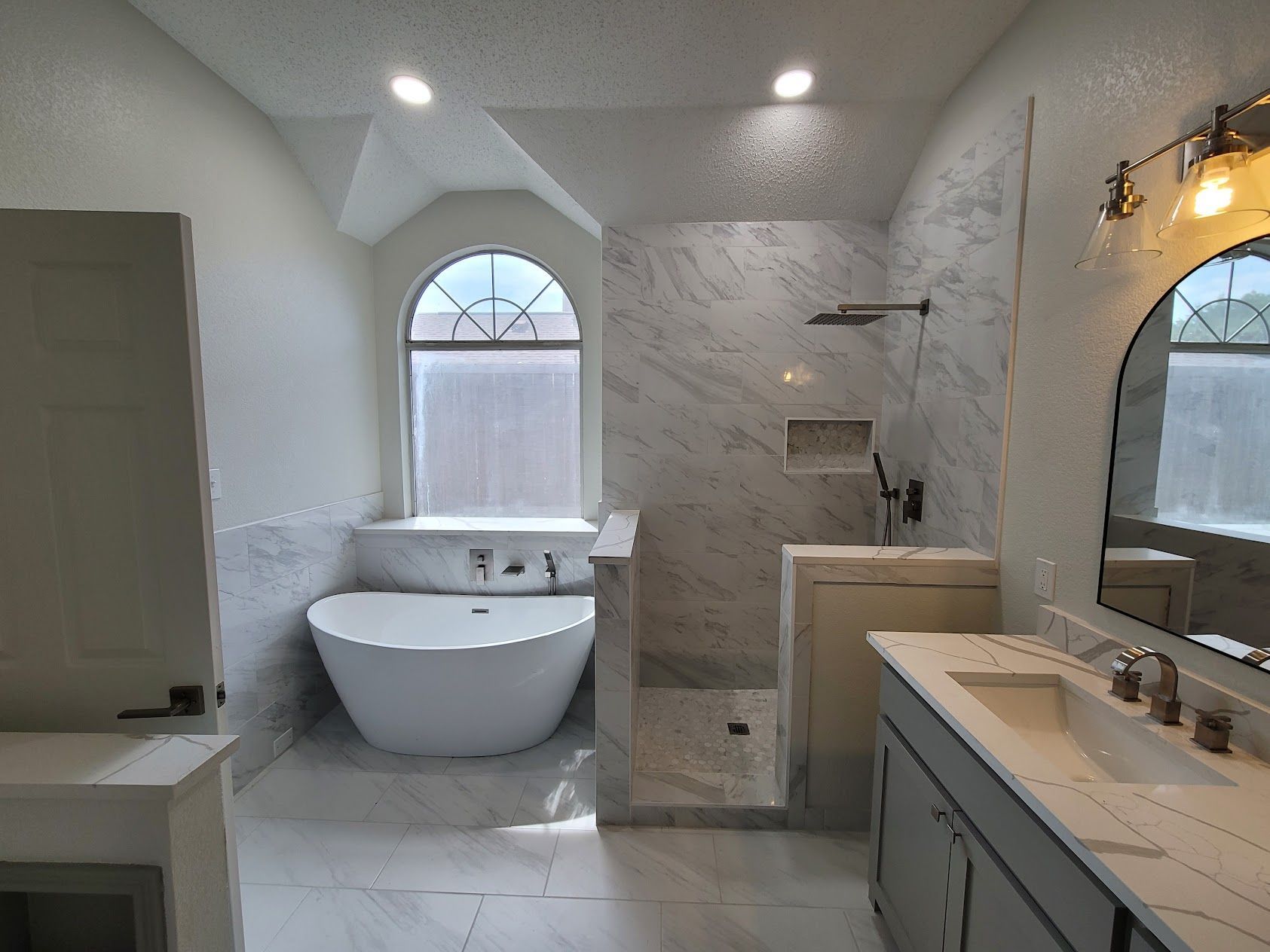 A bathroom with a tub , sink , and shower.