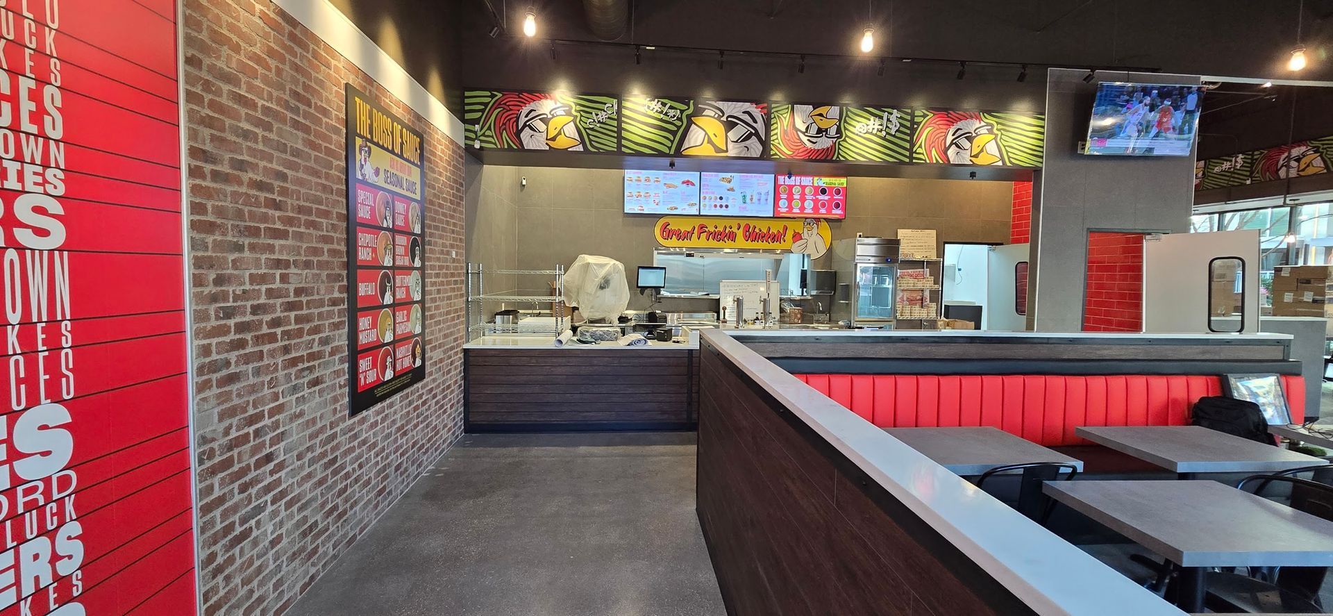 A restaurant with a brick wall and tables and a counter.
