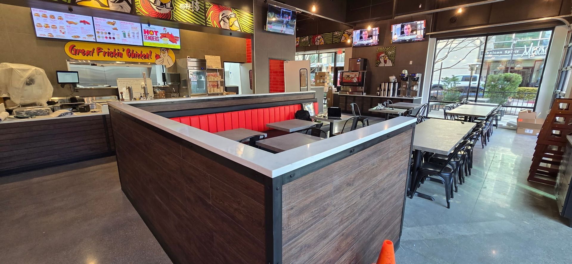 The inside of a restaurant with tables and chairs and a large window.