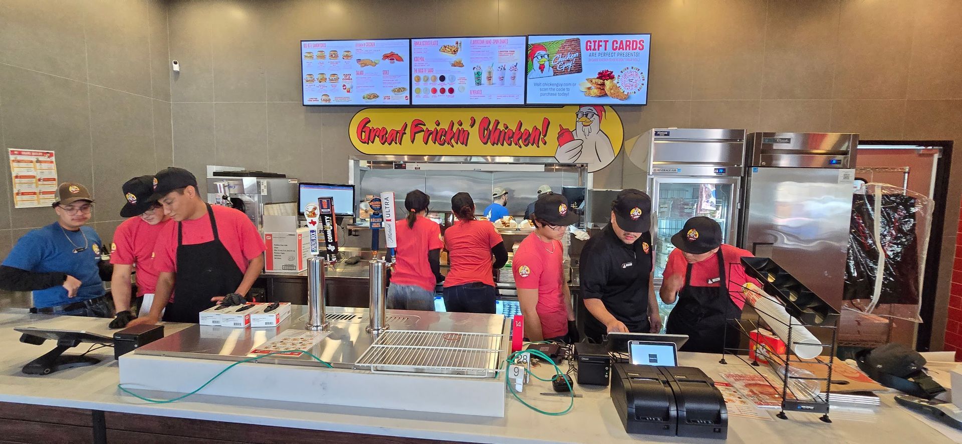A group of people are standing around a counter in a restaurant.