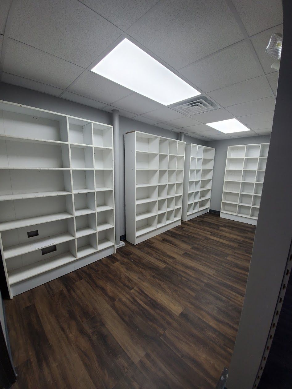 A room with a lot of shelves and a wooden floor.